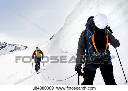 Rear view of mountaineers ski touring on snow-covered mountain, Saas Fee, Switzerland View Large Photo Image Stock Photo - Rear view of mountaineers ski touring on snow-covered mountain, Saas Fee, Switzerland. Fotosearch