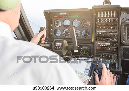 Rear view of pilot in cockpit of aircraft, in flight View Large Photo Image Picture - Rear view of pilot in cockpit of aircraft, in flight. Fotosearch