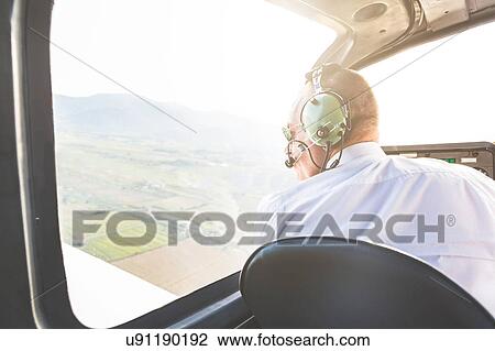 Rear view of pilot in cockpit of aircraft in flight View Large Photo Image Stock Image - Rear view of pilot in cockpit of aircraft in flight. Fotosearch