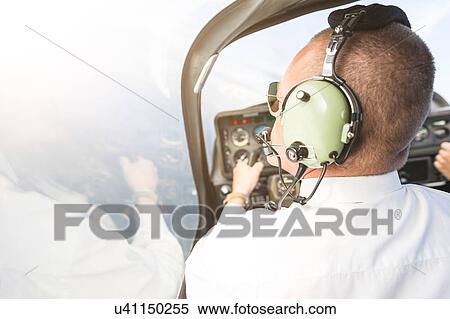 Rear view of pilot in cockpit of aircraft, in flight View Large Photo Image Stock Photography - Rear view of pilot in cockpit of aircraft, in flight. Fotosearch