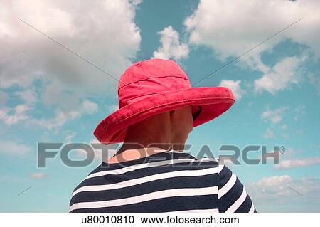 Rear view of woman wearing red sunhat View Large Photo Image Stock Image - Rear view of woman wearing red sunhat. Fotosearch
