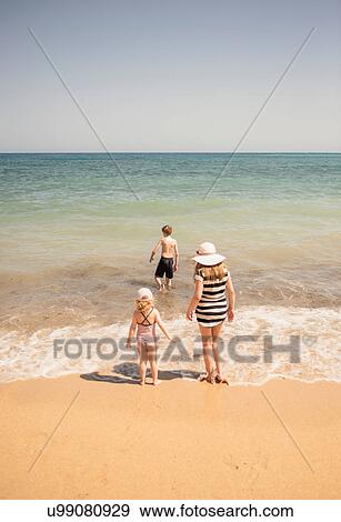 Rear view of woman with son and daughter paddling in sea, Altea, Alicante Province, Spain View Large Photo Image Stock Photo - Rear view of woman with son and daughter paddling in sea, Altea, Alicante Province, Spain. Fotosearch