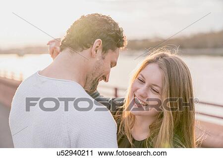 Romantic couple on waterfront at sunset, Battersea Park, London, UK View Large Photo Image Stock Image - Romantic couple on waterfront at sunset, Battersea Park, London, UK. Fotosearch
