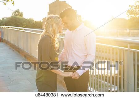 Stock Image - Romantic young couple face to face on sunlit Regent's Canal, London, UK. Fotosearch