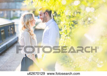 Romantic young couple holding hands and face to face at Regent's Canal, London, UK View Large Photo Image Stock Photo - Romantic young couple holding hands and face to face at Regent's Canal, London, UK. Fotosearch