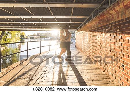 Stock Image - Romantic young couple under bridge on Regent's Canal, London, UK. Fotosearch