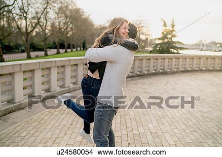 Romantic young man hugging girlfriend in Battersea Park, London, UK View Large Photo Image Picture - Romantic young man hugging girlfriend in Battersea Park, London, UK. Fotosearch
