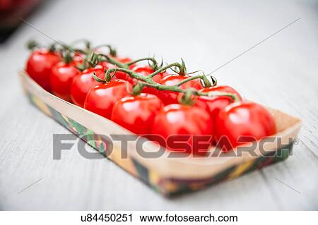 Stock Image - Rows of vine tomatoes in box. Fotosearch