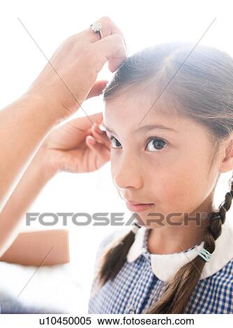Schoolgirl getting hair done by her mother View Large Photo Image Stock Photography - Schoolgirl getting hair done by her mother. Fotosearch