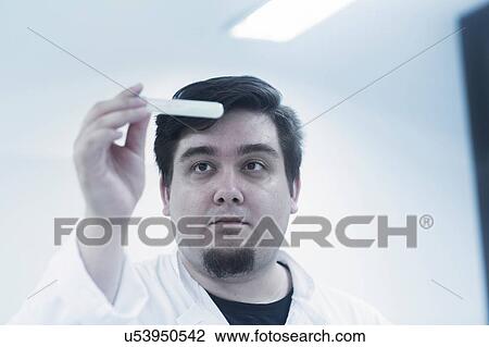 Scientist examining sample in test tube View Large Photo Image Stock Image - Scientist examining sample in test tube. Fotosearch