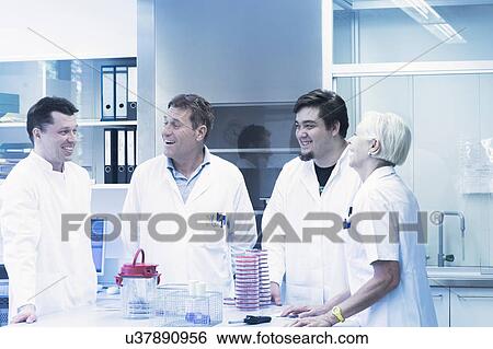 Stock Photograph - Scientists laughing in laboratory. Fotosearch