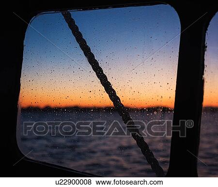 Stock Photo - Sea at sunset seen through boat window. Fotosearch