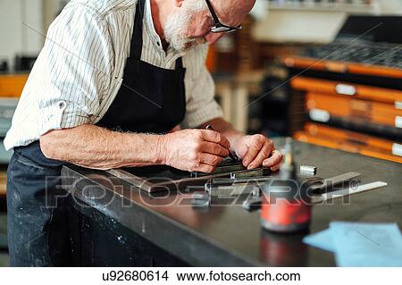 Picture - Senior craftsman working on letterpress in print workshop. Fotosearch