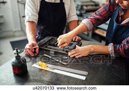 Senior craftsman working on letterpress with young craftswoman in print workshop, mid section View Large Photo Image Stock Image - Senior craftsman working on letterpress with young craftswoman in print workshop, mid section. Fotosearch