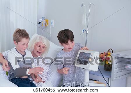 Senior female patient in hospital bed with grandsons playing with blood pressure machine View Large Photo Image Stock Photography - Senior female patient in hospital bed with grandsons playing with blood pressure machine. Fotosearch