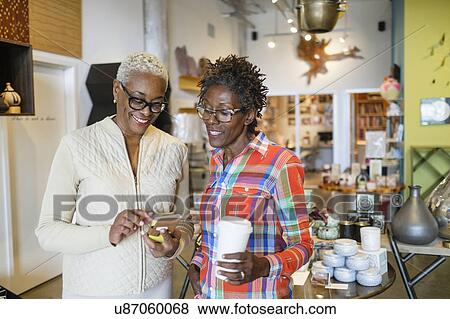 Stock Photo - Shop owners using mobile phone. Fotosearch
