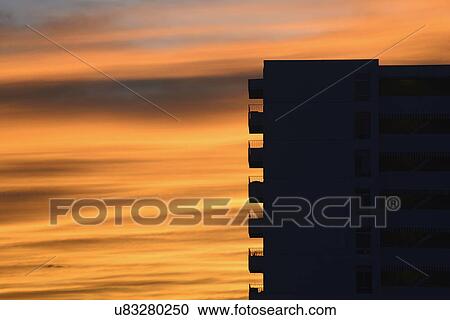 Stock Image - Silhouette of apartment building at dusk. Fotosearch
