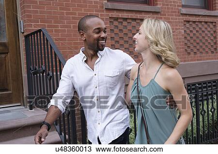 Smiling couple walking in residential district View Large Photo Image Stock Image - Smiling couple walking in residential district. Fotosearch