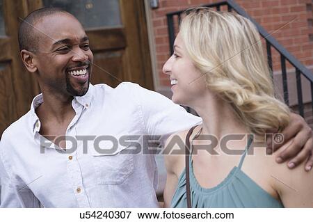 Stock Photo - Smiling couple walking in residential district. Fotosearch