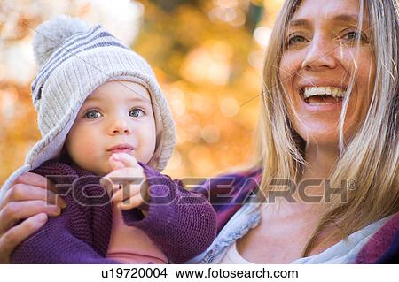 Picture - Smiling mother holding baby girl. Fotosearch