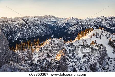 Stock Photo - Snow-covered mountain landscape at sunrise, Teufelstattkopf mountain, Oberammergau, Bavaria, Germany. Fotosearch