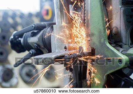 Stock Image - Sparks on grinding machine. Fotosearch