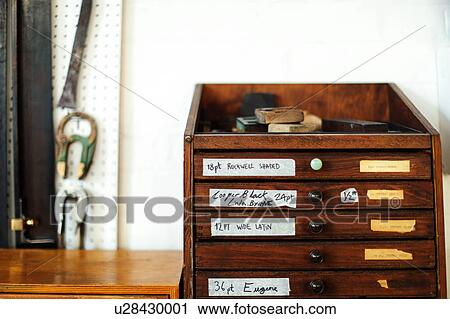 Stock Image - Still life of wooden drawers and equipment in print workshop. Fotosearch