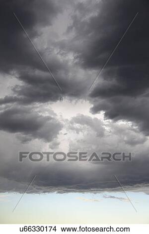Storm clouds gathering on late evening sky View Large Photo Image Picture - Storm clouds gathering on late evening sky. Fotosearch