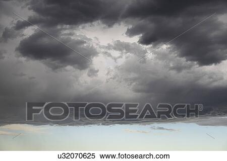 Stock Photography - Storm clouds gathering on late evening sky. Fotosearch