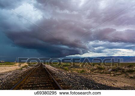 Storms moving over plains into the mountains, as seen over railroad tracks near Alamogordo, New Mexico View Large Photo Image Stock Photography - Storms moving over plains into the mountains, as seen over railroad tracks near Alamogordo, New Mexico. Fotosearch