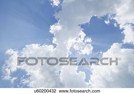 Stock Image - Sun rays shining through clouds. Fotosearch