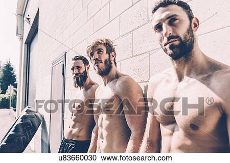 Three bare-chested male cross trainers leaning against wall outside gym View Large Photo Image Stock Image - Three bare-chested male cross trainers leaning against wall outside gym. Fotosearch