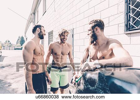 Stock Photo - Three male cross trainers chatting outside gym. Fotosearch