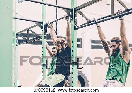 Three male cross trainers training on exercise bar in gym View Large Photo Image Stock Image - Three male cross trainers training on exercise bar in gym. Fotosearch