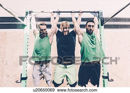 Stock Photo - Three male cross trainers training on exercise bar in gym. Fotosearch