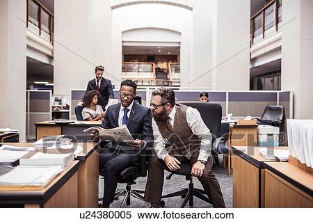 Two businessmen reading broadsheet in office View Large Photo Image Stock Photography - Two businessmen reading broadsheet in office. Fotosearch