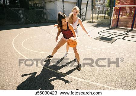 Two female basketball players practising on basketball court View Large Photo Image Stock Image - Two female basketball players practising on basketball court. Fotosearch