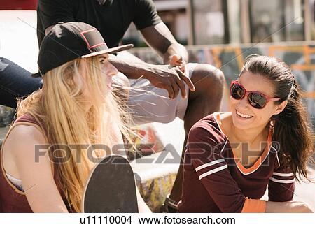 Two female friends chatting in city skatepark View Large Photo Image Picture - Two female friends chatting in city skatepark. Fotosearch