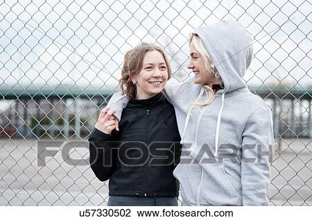 Two female running friends by wire fence View Large Photo Image Stock Image - Two female running friends by wire fence. Fotosearch