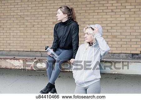 Two female running friends looking sideways outside warehouse View Large Photo Image Stock Photograph - Two female running friends looking sideways outside warehouse. Fotosearch