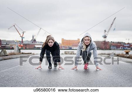 Two female running friends on their mark on dockside road View Large Photo Image Stock Photograph - Two female running friends on their mark on dockside road. Fotosearch