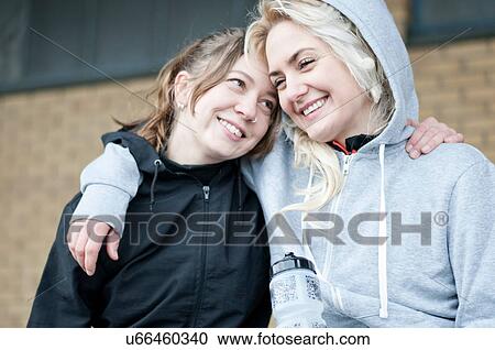 Two female running friends with arms around each other View Large Photo Image Stock Image - Two female running friends with arms around each other. Fotosearch