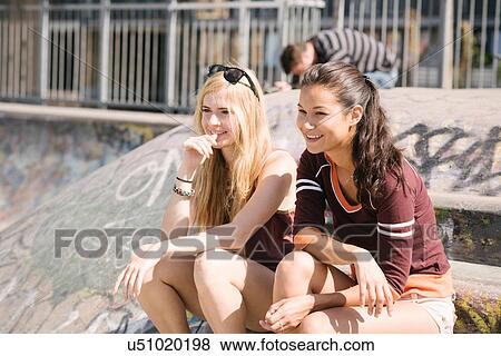 Two female skateboarders sitting in skatepark View Large Photo Image Stock Photo - Two female skateboarders sitting in skatepark. Fotosearch