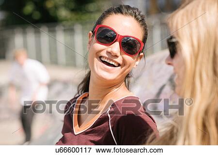 Two female skateboarding friends laughing in skatepark View Large Photo Image Stock Photo - Two female skateboarding friends laughing in skatepark. Fotosearch