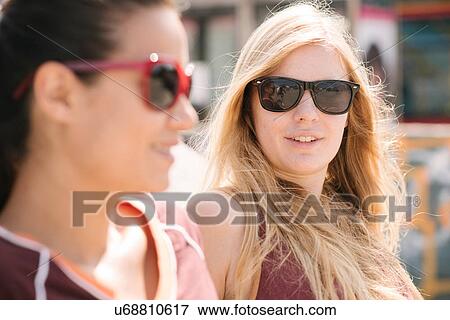 Stock Photo - Two female skateboarding friends chatting in skatepark. Fotosearch