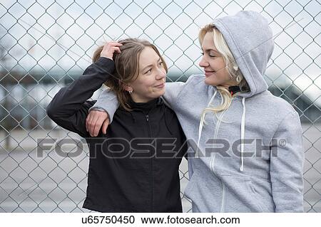 Two happy female runner friends by wire fence View Large Photo Image Stock Image - Two happy female runner friends by wire fence. Fotosearch