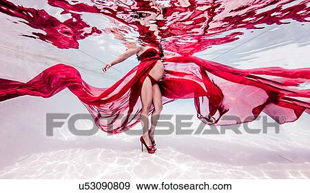 Underwater view of pregnant woman draped in sheer red fabric View Large Photo Image Stock Photo - Underwater view of pregnant woman draped in sheer red fabric. Fotosearch