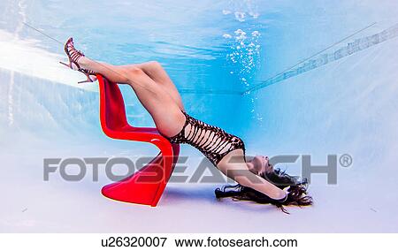 Underwater view of woman resting upside down on chair, feet at surface of water View Large Photo Image Stock Photo - Underwater view of woman resting upside down on chair, feet at surface of water. Fotosearch