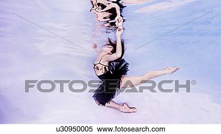 Underwater view of woman wearing tutu and ballet shoes, hand breaking surface of water View Large Photo Image Stock Photography - Underwater view of woman wearing tutu and ballet shoes, hand breaking surface of water. Fotosearch