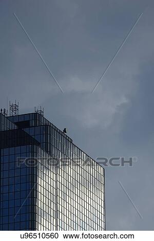 Stock Image - USA, Boston, Massachusetts, Glass office building and cloudy sky. Fotosearch